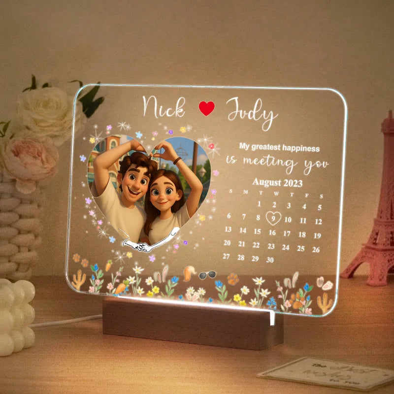 Illuminated cartoon couple photo light displayed on a wooden base