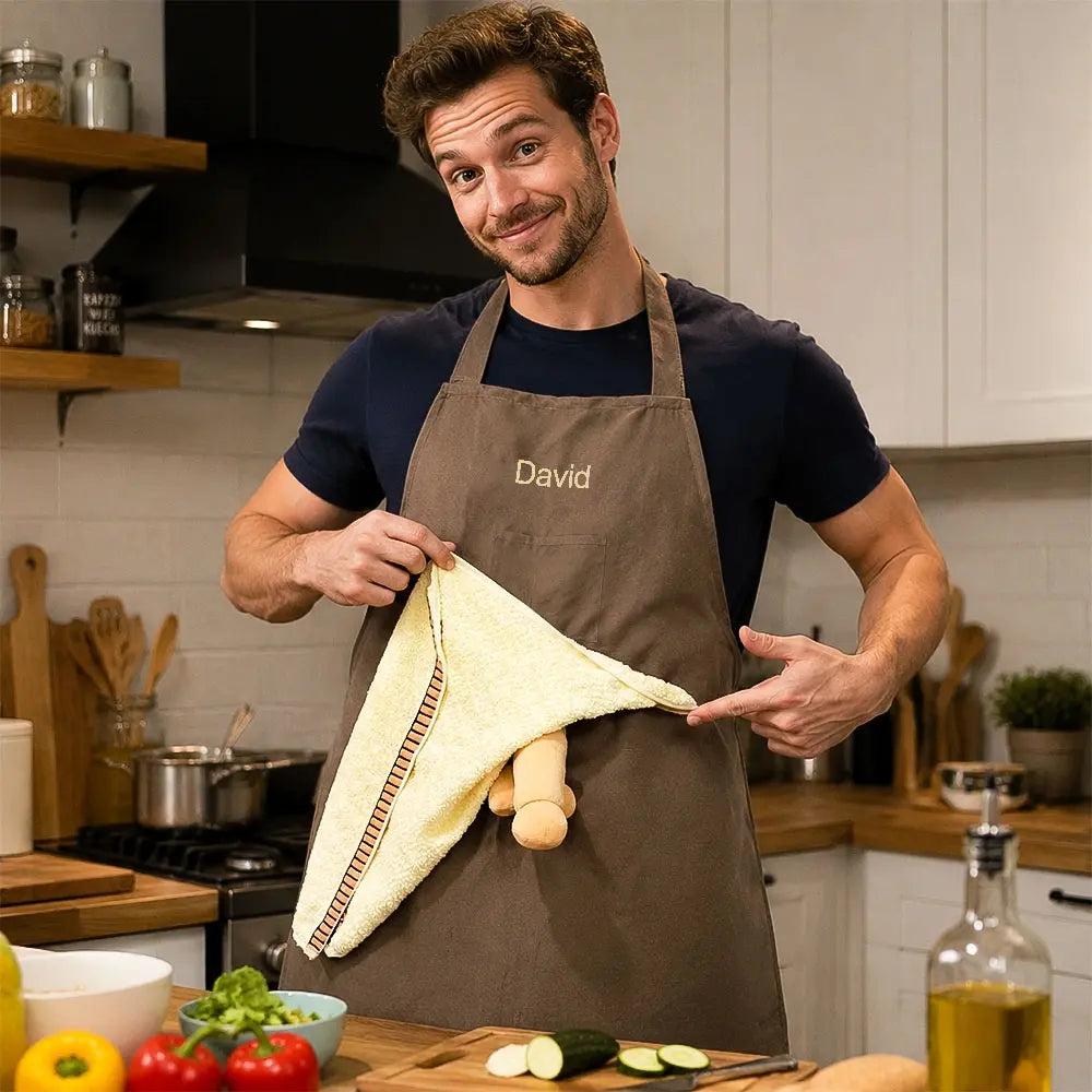 Personalized brown BBQ apron worn in a kitchen with its hidden novelty panel revealed