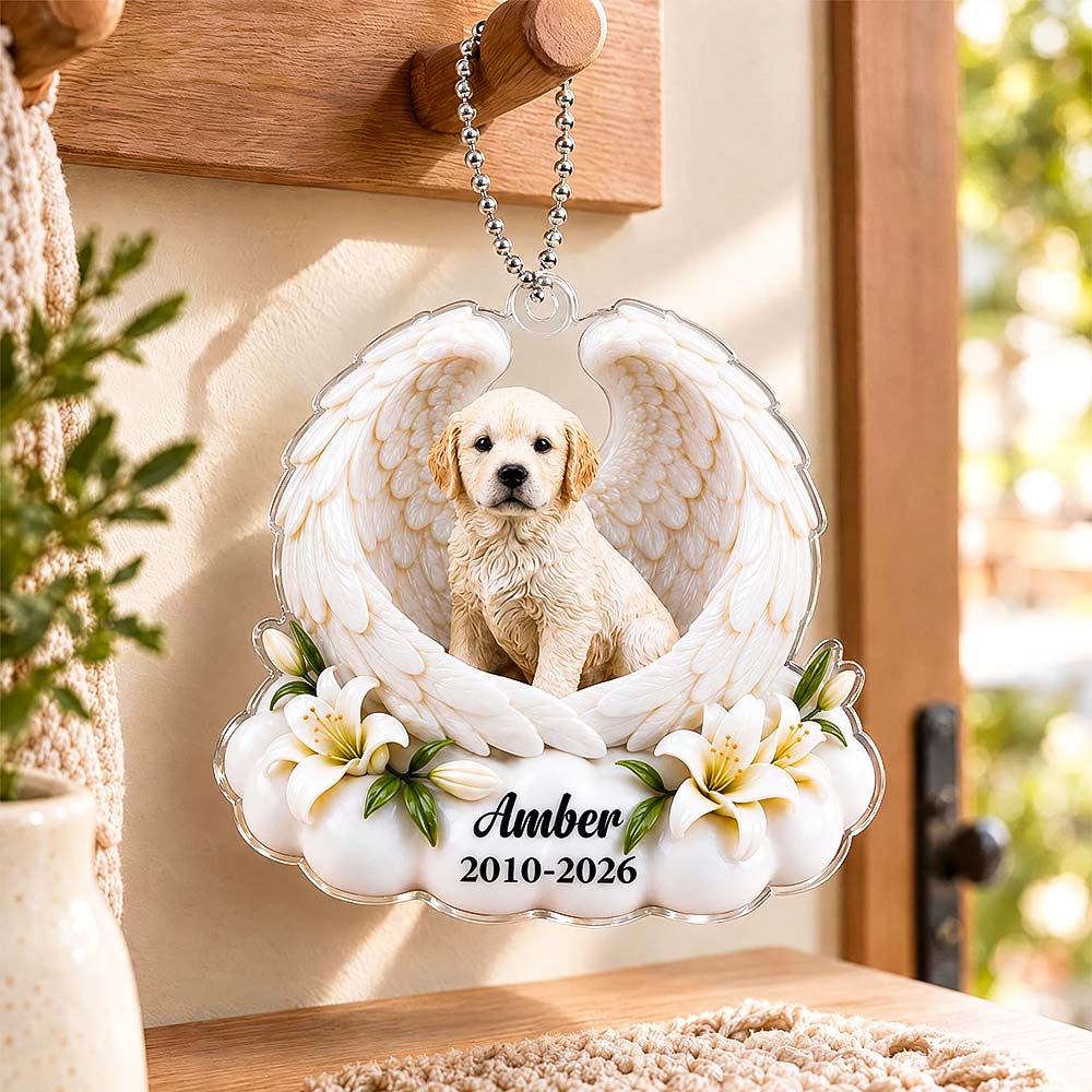 Hand holding an angel-wing pet memorial ornament with a dog portrait