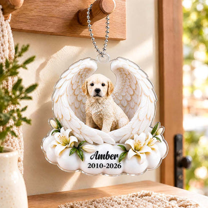 Hand holding an angel-wing pet memorial ornament with a dog portrait