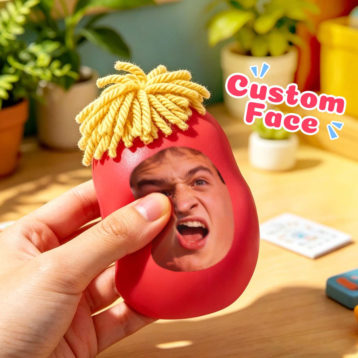 Red custom photo face squishy toy being squeezed by hand