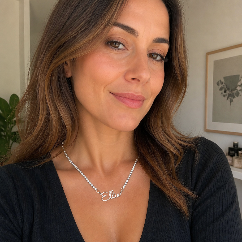 Woman wearing a silver-color custom name tennis necklace with a black top