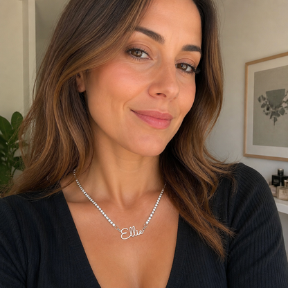 Woman wearing a silver-color custom name tennis necklace with a black top
